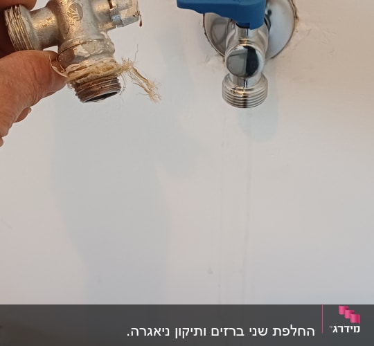 ברז מים עם ידית כחולה על קיר לבן